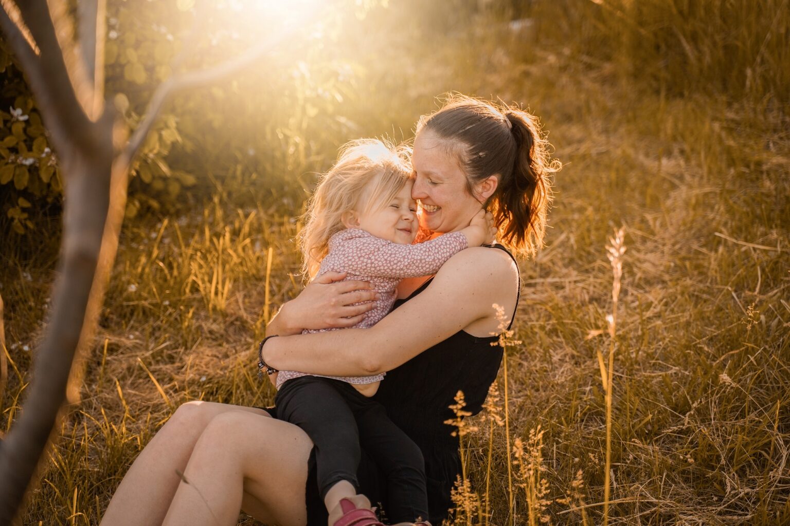 Mama und Tochter kuscheln in der Natur